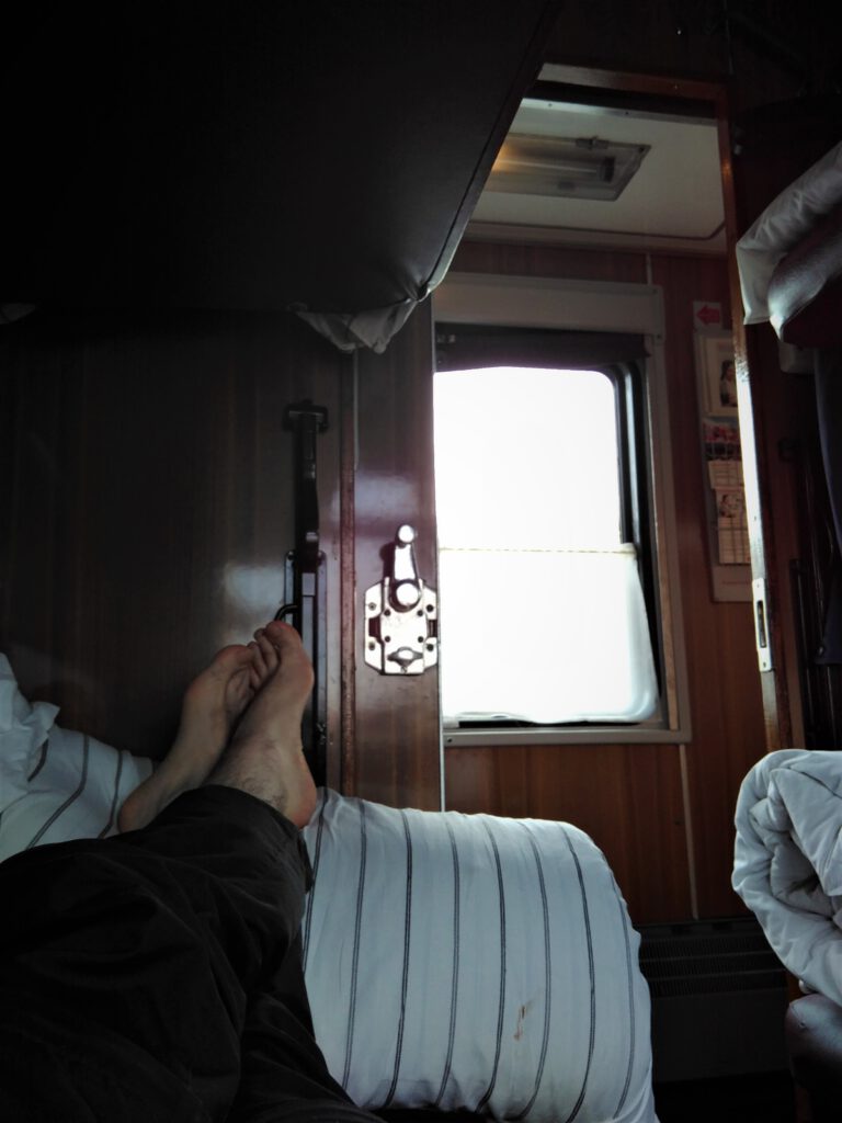 Ausgestreckte Beine auf einer Koje im Kupe der Transsibirien Eisenbahn nach Nowosibirsk.