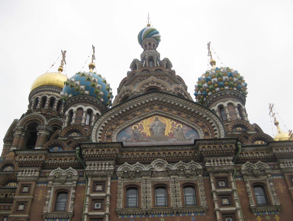 Sehenswürdigkeiten St Petersburg. Nahaufnahme der Kirche des Erlösers auf vergossenem Blut.  Barocke Fassade mit Freske und bunten Zwiebeltürmen.храм Спа́са на Крови́