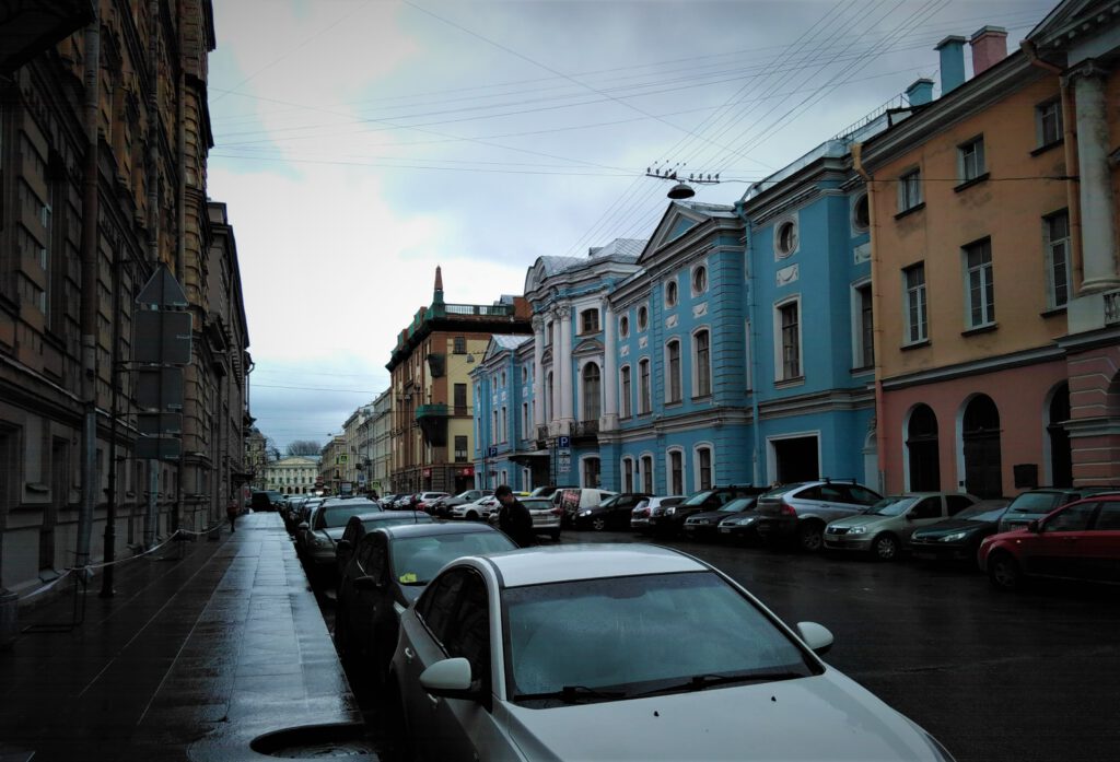 Blick in Seitenstraße in St. Petersburg. Auffällig ist ein blaues klassizistisches Haus auf der rechten Straßenseite. 