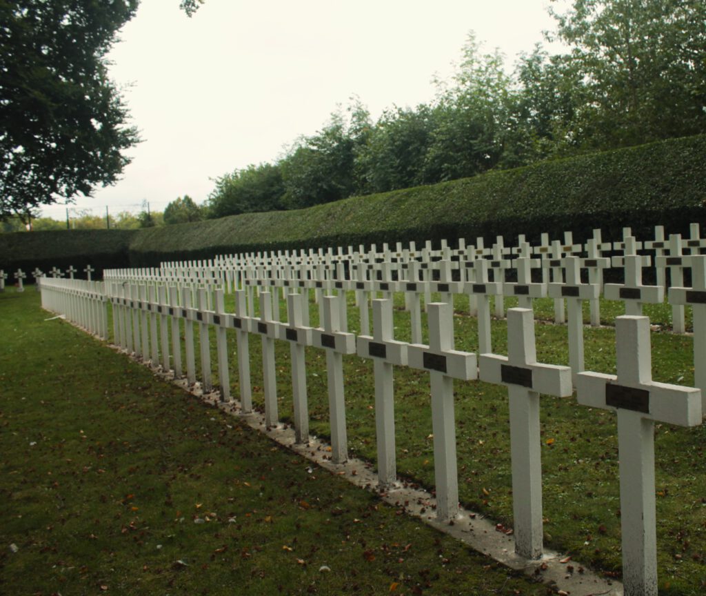 Gedenkfriedhof "Enclos des fusillés de Liège": Vier Reihen von weißen Kreuzen auf dem Friedhofsrasen.