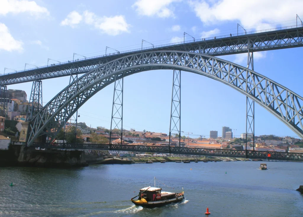 Boot auf Douro fährt unter die Brücke Luis 1.