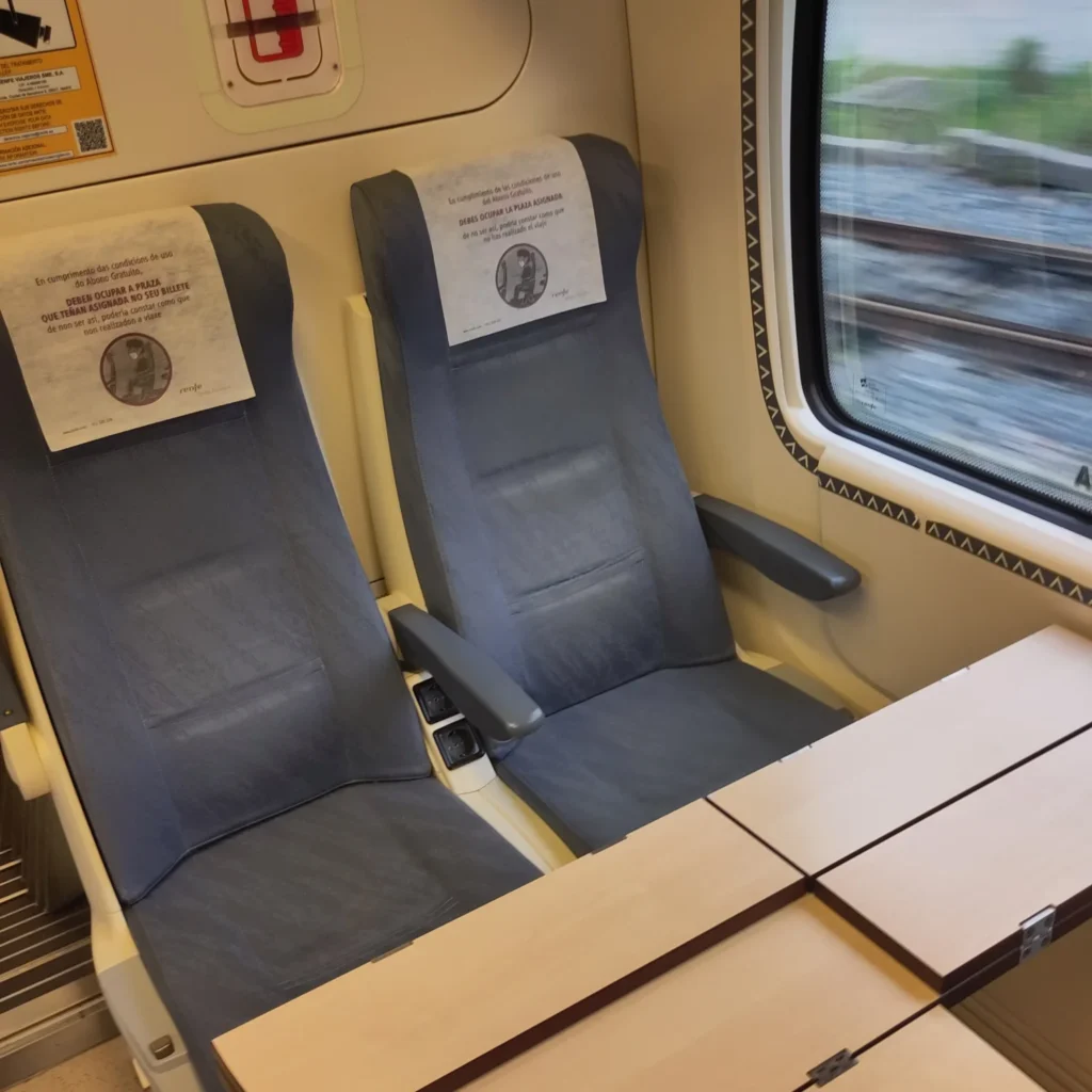 Zwei leere Sitze am Vierer mit Tisch im Renfe Regionalzug nach Vigo. 