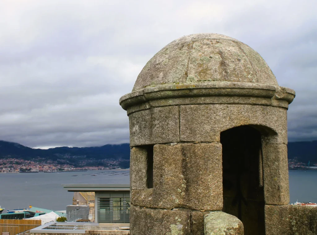 Kleiner, runder Wachturm vor der Ria Vigo. Bewölkter Himmel.
