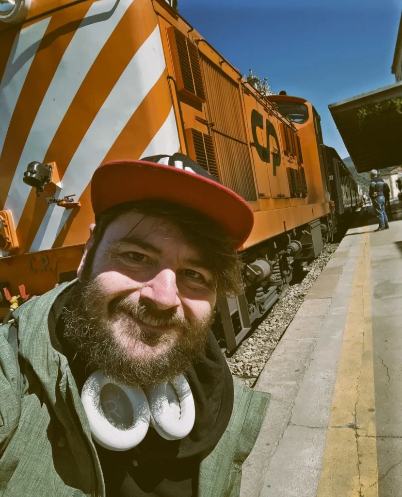 Selfie vor orange-weiß gestreifter Diesellokomotive der Baureihe 1400