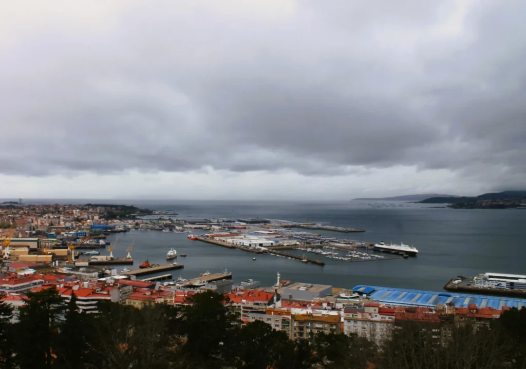 Stark bewölkter Himmel über Bucht von Vigo. Pier und Jachthafen.
