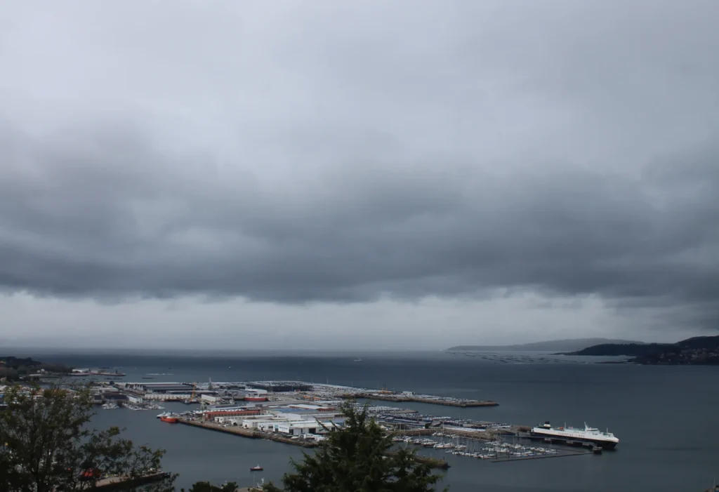 Stark bewölkter Himmel über Bucht von Vigo. Pier und Jachthafen.