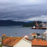 Blick richtung Hafen in der Ria Vigo, mit Frachtschiffen und Gebirgsstreifen in der Kulisse.
