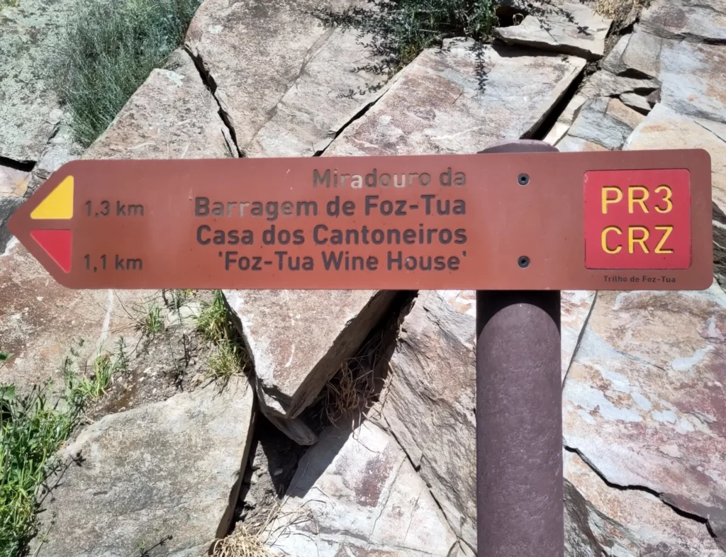 Bahnwandern in Tua: Pfeilförmiges Schild, das den Wanderweg PR3 CRZ in Tua anzeigt. Zur Talsperre sind es 1,3 Kilometer.