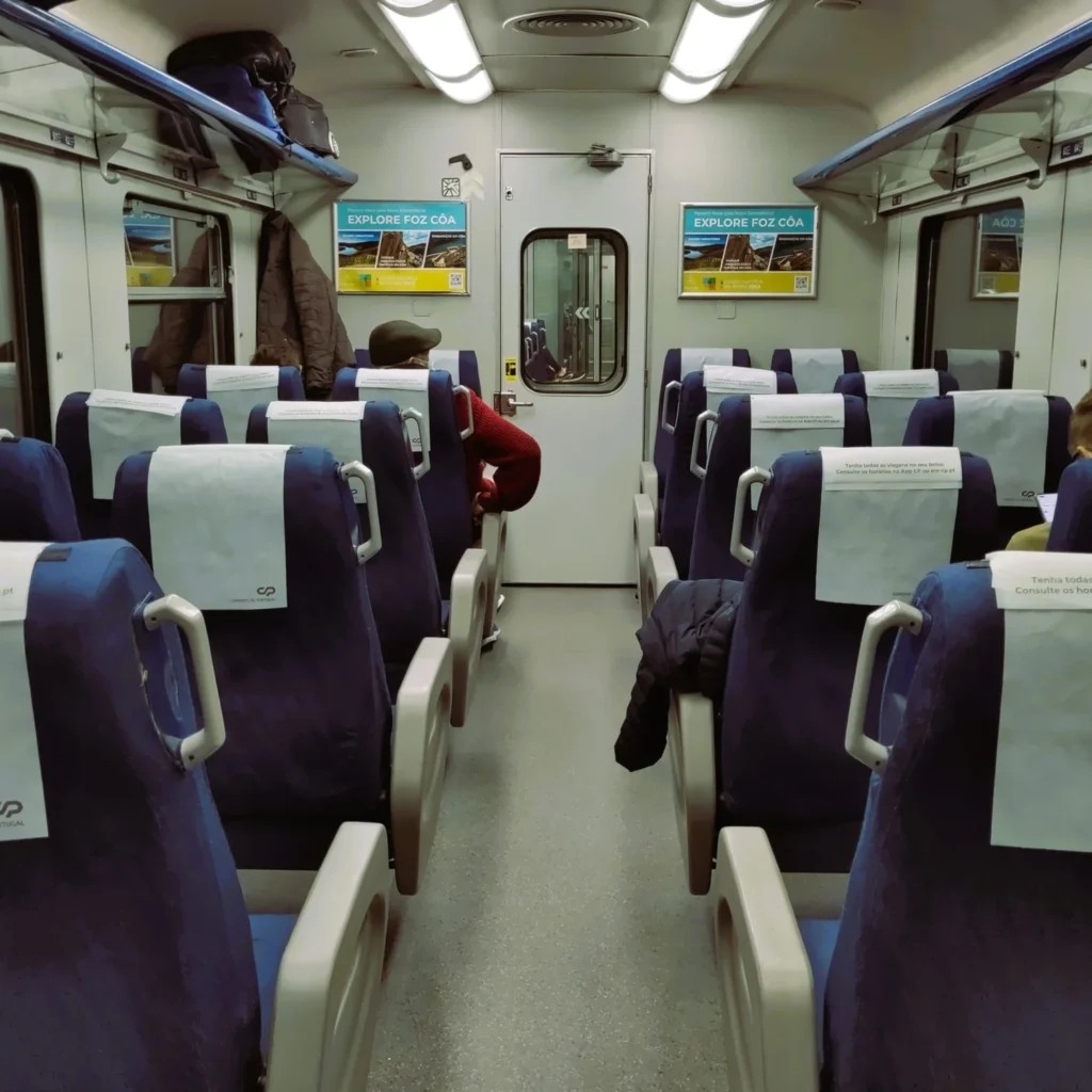 Zugabteil im Zug Celta Porto. Blaue Sitze in zwei Zweierreihen